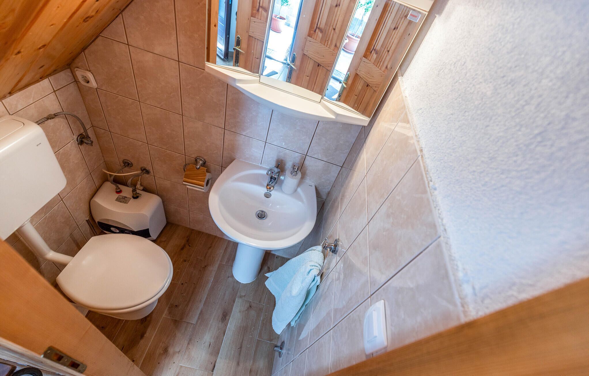 Ein kleines Badezimmer mit Toilette, Waschbecken und Spiegel.