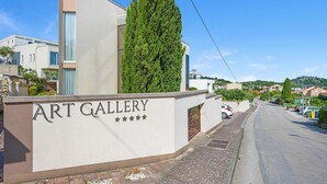 A modern building with a sign reading "ART GALLERY" and a tall, narrow tree in front. - Lovely apartment in Murter with WiFi - CSV284 (Murter)