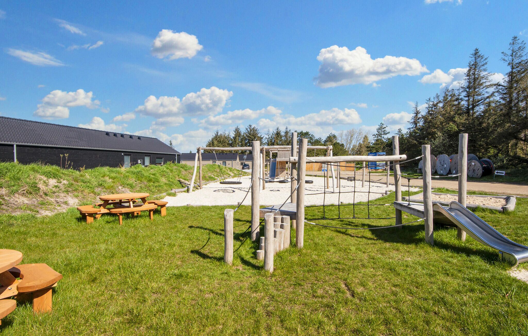 A playground with a slide, swings, and a picnic table.