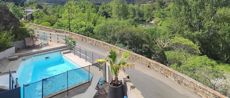 Relax by the serene pool surrounded by lush greenery and rolling hills.