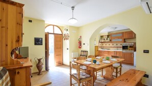 A cozy kitchen with wooden cabinets, a dining table set for four, and a large window.