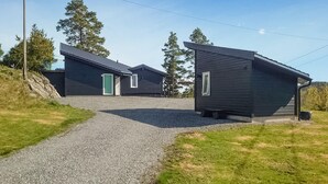 A modern building with a gravel driveway leading to a wooden structure. - Beautiful home in Trøgstad (Trøgstad)