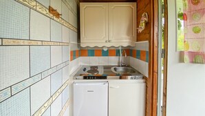 Eine kleine Küche mit Kühlschrank, Herd und Spüle.