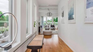 A spacious hallway with a wooden floor, a bench, and a view of the outdoors. - Beautiful home in Sparsör (Sparsör)
