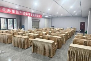 A conference room with multiple tables covered in beige tablecloths, arranged in rows. - Yi Cheng Hotel (Xinbai Square Subway Station Store, Shijiazhuang) (Shijiazhuang)