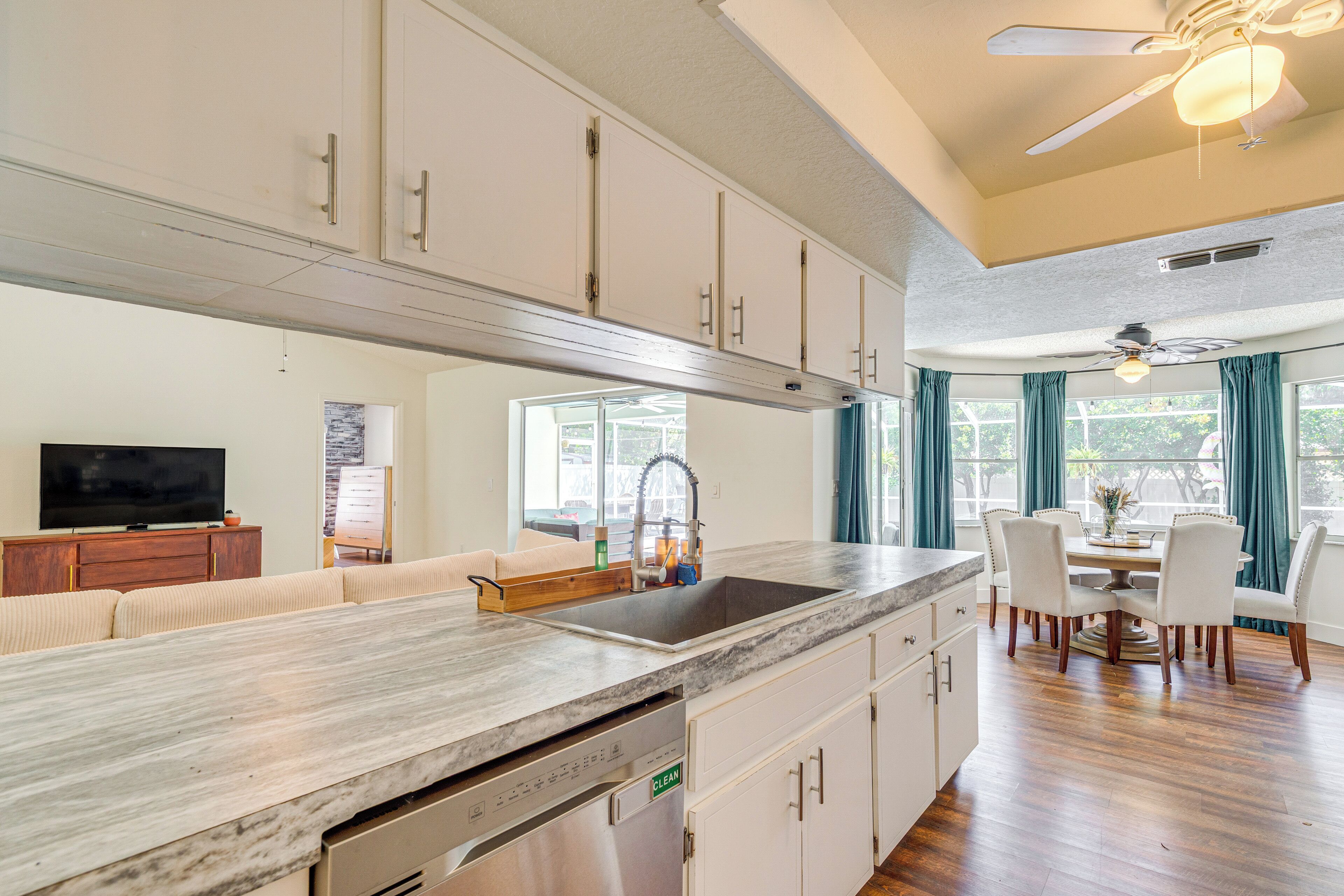 A modern kitchen with a large island, built-in appliances, and a dining area with a table and chairs.