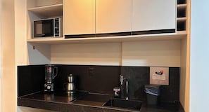 A modern kitchen with a microwave, coffee maker, and blender on the counter.
