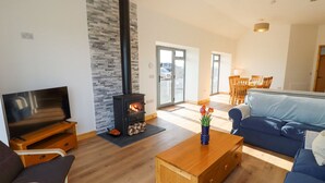 Una sala de estar con televisor, chimenea, sofá y una mesa de centro.