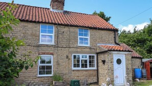 A stone house with a tiled roof, multiple windows, and a front door. - 2 Beck Houses (Malton)