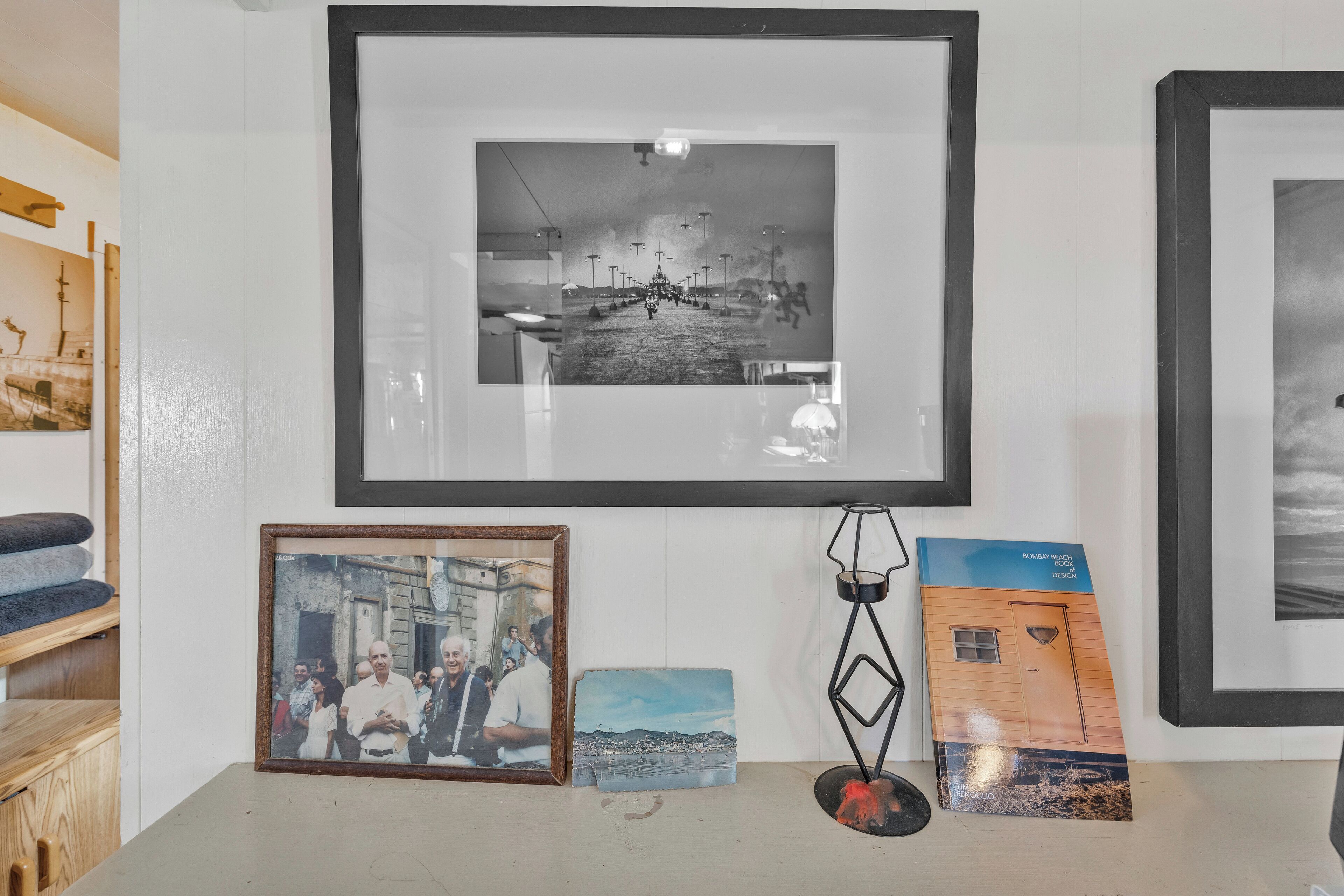 A wall with framed photographs and a book.