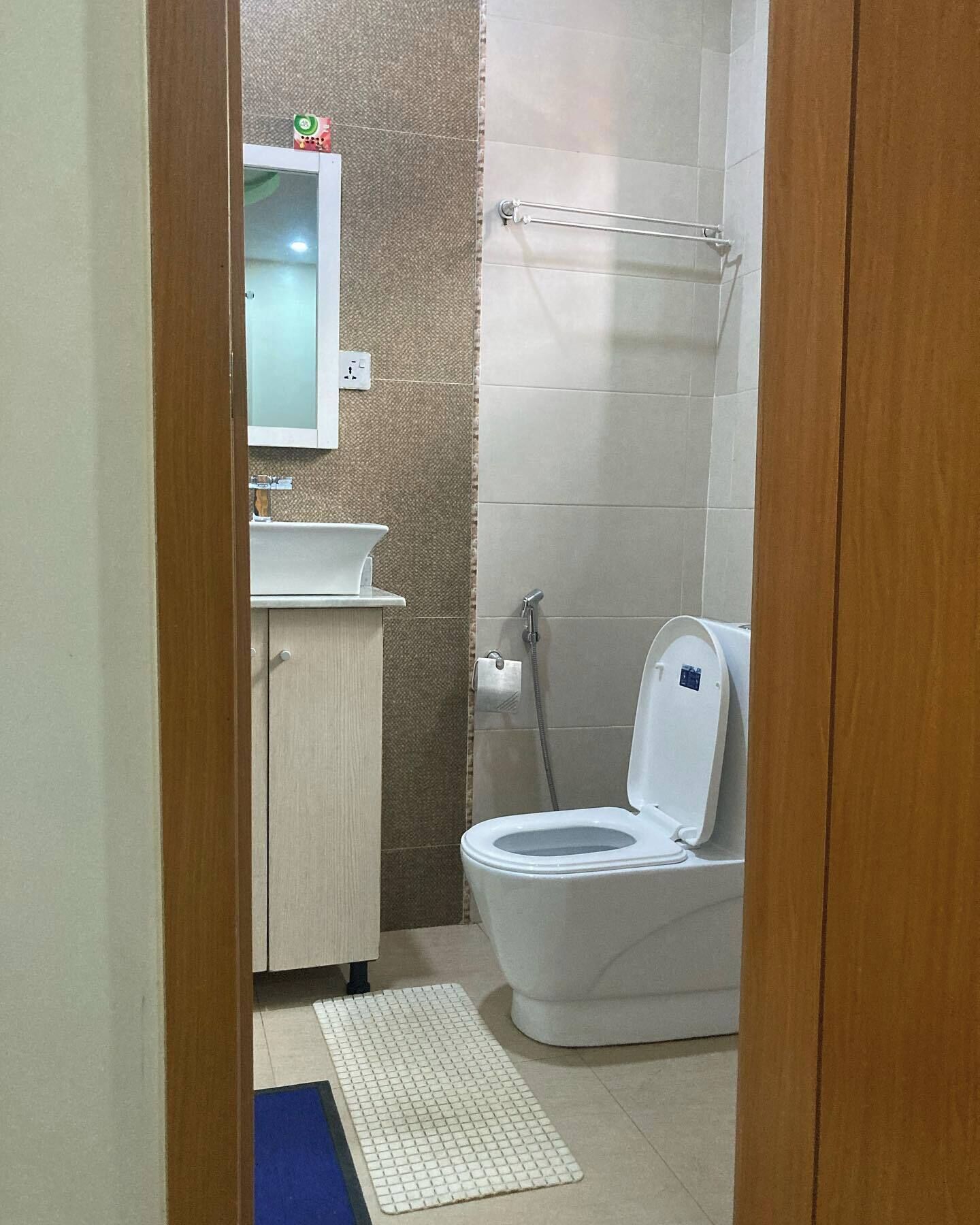 A small bathroom with a toilet, sink, and mirror.