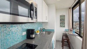 A compact kitchen with a microwave, coffee maker, and a sink. - Awesome view. Walking distance to beach, restaurants, shopping (Honolulu)