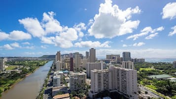 Un paysage urbain avec de hauts immeubles, une rivière et un ciel dégagé.