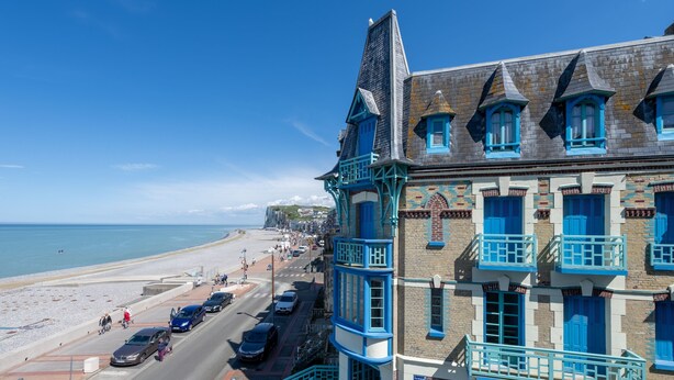 Un edificio costero con varios balcones y vista a la playa.