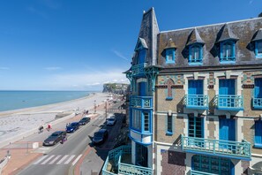 Un bâtiment situé sur la côte, doté de nombreux balcons et offrant une vue sur la plage.