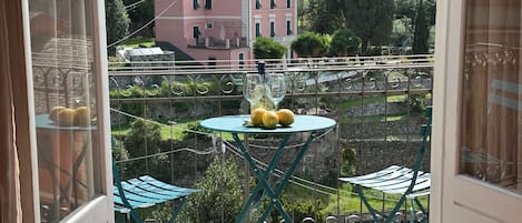 Enjoy a refreshing morning with a view from this balcony, featuring a small table and two chairs.