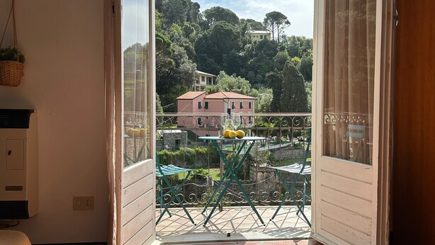 A balcony with a view of a hillside, a table with lemons, and a chair. - Chiaraluce Monte Cosy Apt near best beaches (Monterosso al Mare)