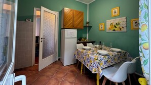A compact kitchen with a dining area, a ceiling fan, and a refrigerator. - Chiaraluce Monte Cosy Apt near best beaches (Monterosso al Mare)