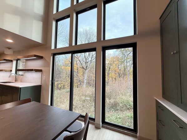 Una cocina moderna con ventanas amplias, una mesa de comedor y armarios empotrados.