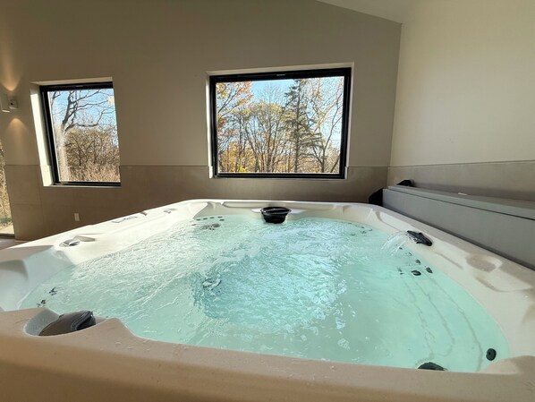 A hot tub with a view of trees through two windows. - 6 Bedroom, 6.5 bathroom with Indoor Pool, Hot Tub & Sauna (Hager City)