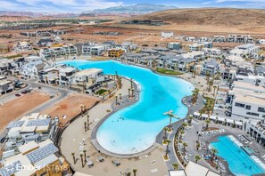 A resort with multiple swimming pools, a beach area, and a desert landscape in the background. - Desert Color Escape (by Ember Stays) (St. George)