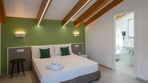 A modern hotel room with a large bed, green walls, wooden beams, and a bathroom visible through an open door. - Rossy Palace4 - Amalficoast Suites (Agerola)