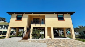 A two-story building with a flat roof, a central entrance, and a staircase leading to the upper floor.