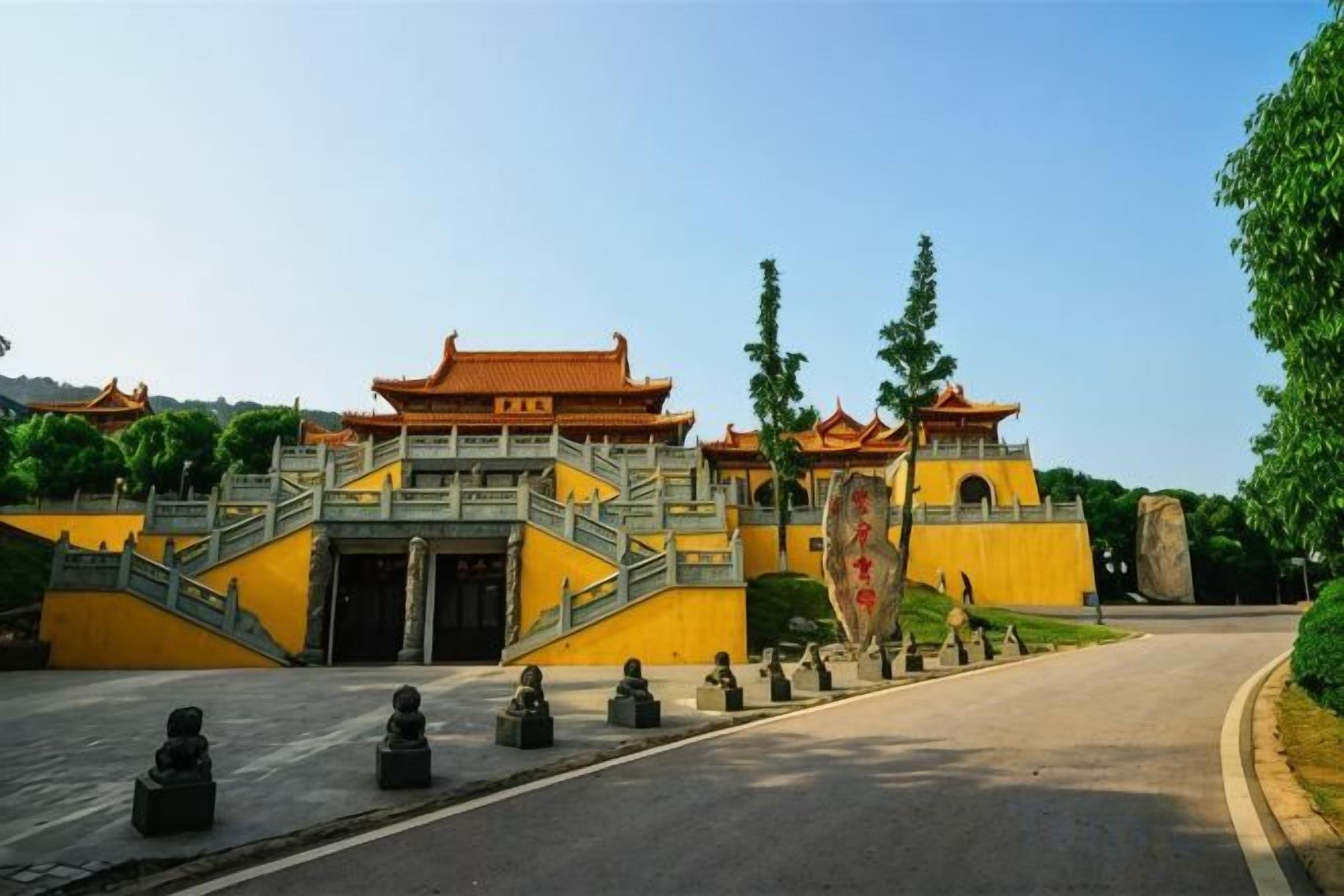 A traditional building with a prominent entrance, a staircase, and a large stone monument.