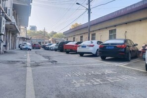 A street lined with parked cars and buildings. - Qingmu Hotel(Shangyuan Street,Dongshan Subway Station,Nanjing) (Nanjing)