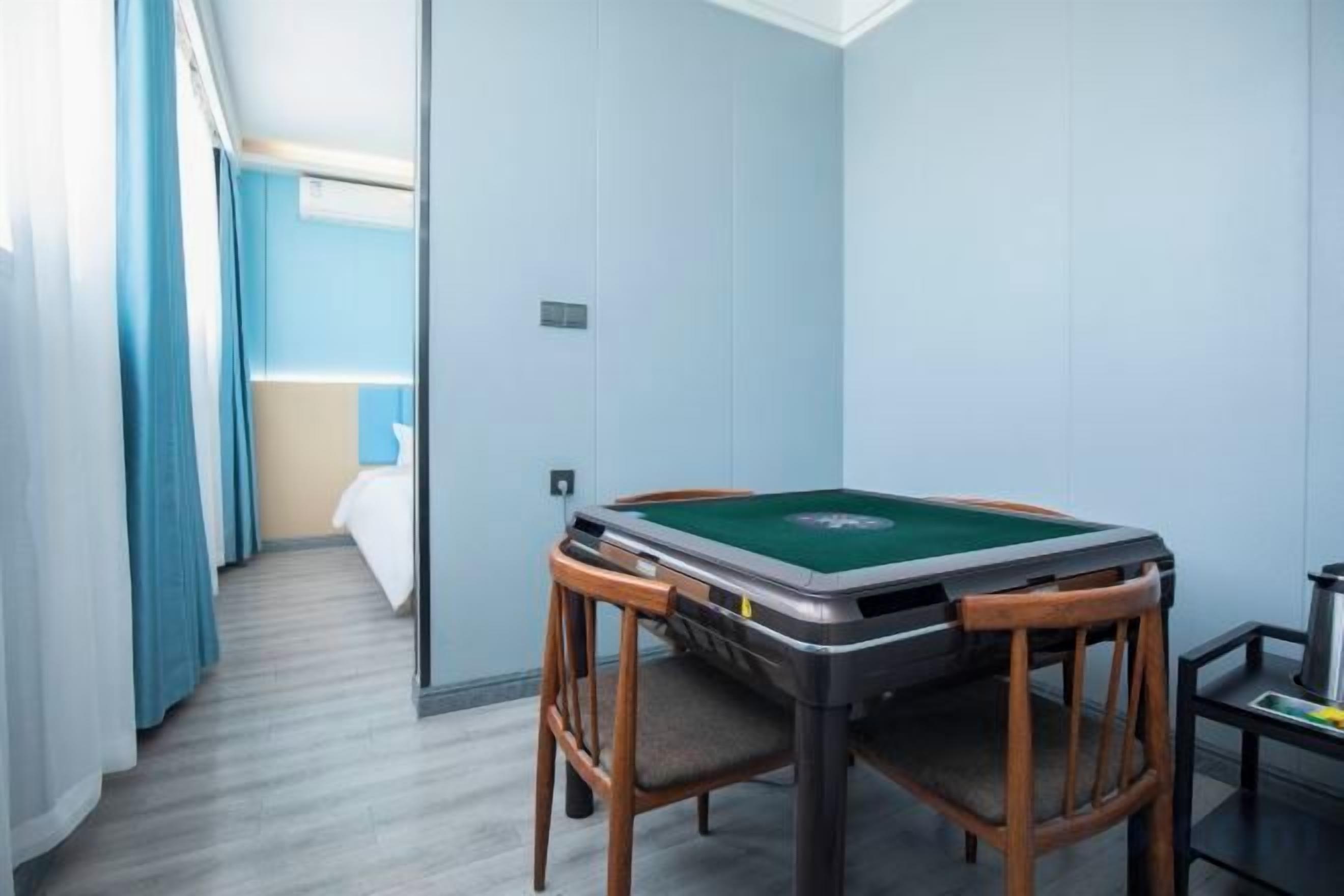 A room with a pool table, a bed, and a window with curtains.