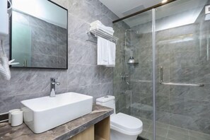 A modern bathroom with a rectangular sink, a toilet, and a glass-enclosed shower. - Qingmu Hotel(Shangyuan Street,Dongshan Subway Station,Nanjing) (Nanjing)