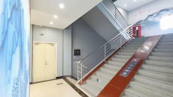 Una escalera con barandillas, una puerta y una pared con un letrero.