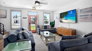 Een moderne woonkamer met een bank, salontafel en televisie.