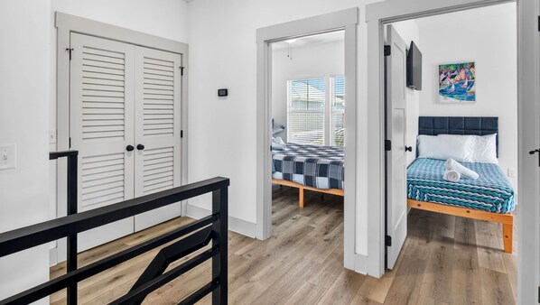 A room with a bed, a bench, and a view through a door.