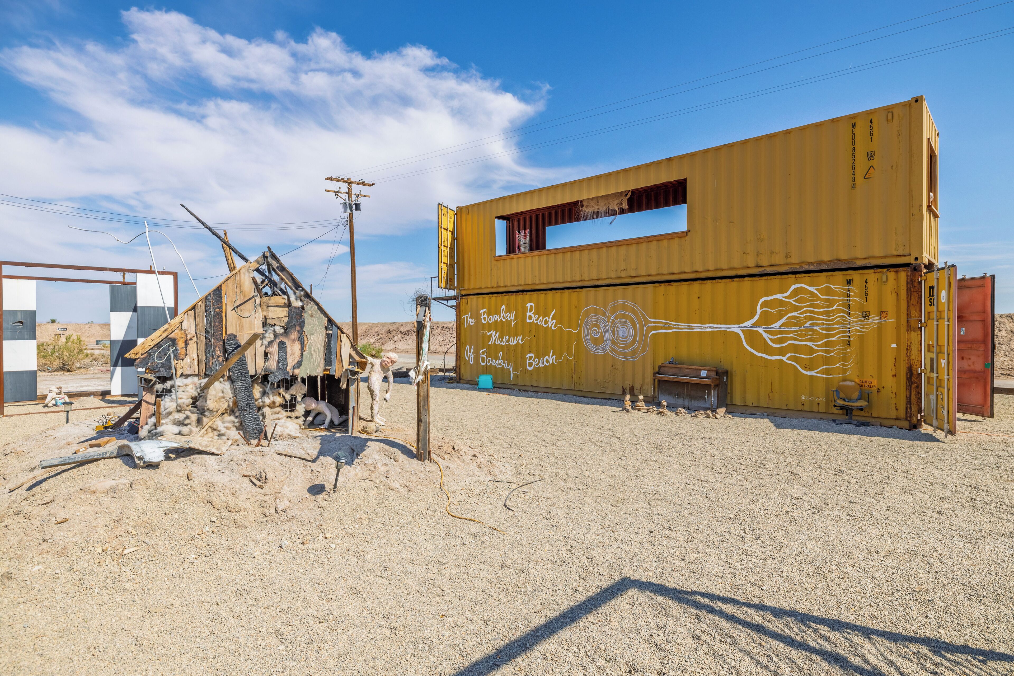 Un container di spedizione giallo di grandi dimensioni, decorato con graffiti e dotato di una finestra.