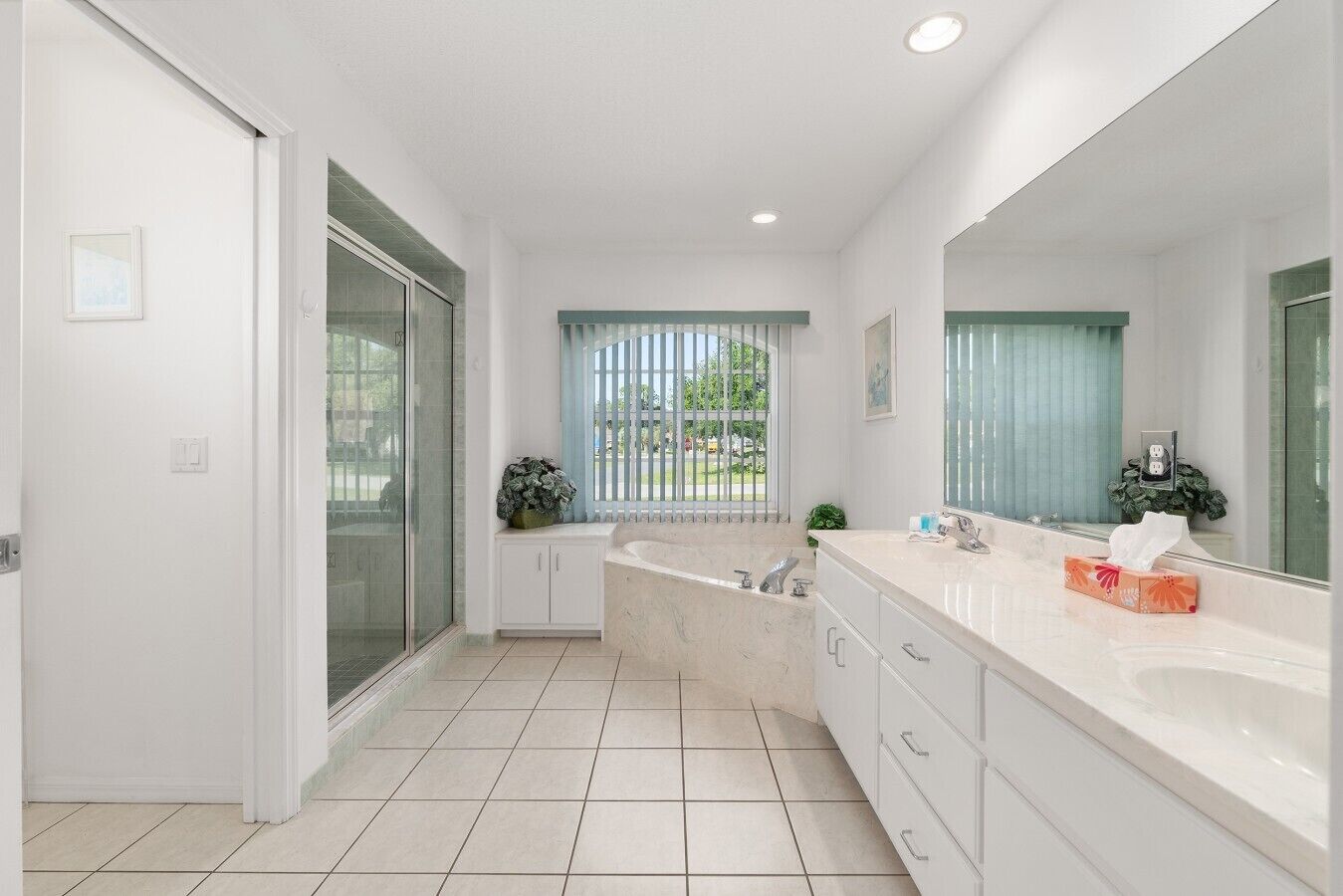 A modern bathroom with a large bathtub, a separate shower area, and a vanity with a mirror.