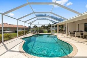 A covered swimming pool with lounge chairs, a patio area, and a view of neighboring houses. - Villa Eckhardt: Bright and Light 3 bedroom home (Inverness)