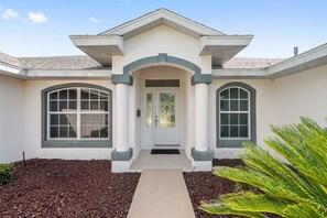 A two-story house with a central entrance, large windows, and a landscaped front yard. - Villa Eckhardt: Bright and Light 3 bedroom home (Inverness)