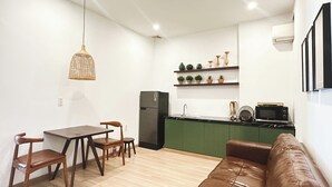 A compact living space with a dining area, kitchenette, and a seating area.