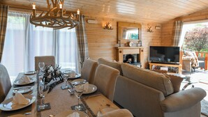 Ein gemütliches Blockhausschlafzimmer mit Essbereich, Sofa, Kamin und Fernseher.