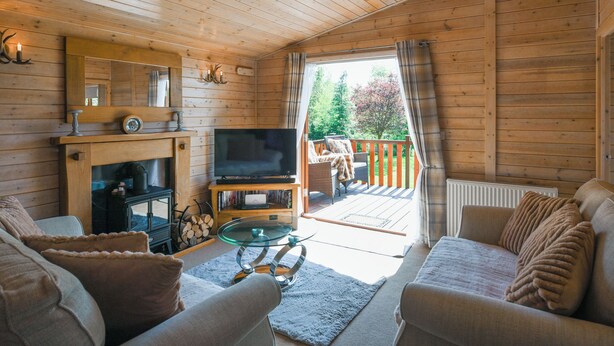 Ein gemütliches Blockhaus-Interieur mit Fernseher, Kamin und Sitzecke.