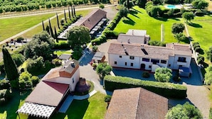 An aerial view of a property with multiple buildings, a swimming pool, and well-maintained gardens.