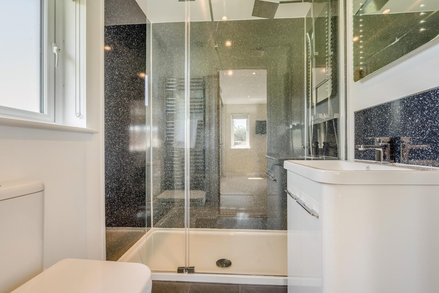 Une salle de bain moderne avec une douche à parois de verre, une baignoire et un meuble-lavabo avec un miroir.