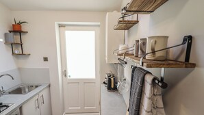 Una cucina moderna con forno integrato, lavello e finestra sopra la porta.