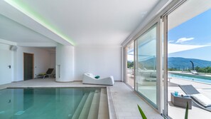 A modern indoor pool area with a clear view of the mountains.