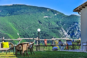 A terrace with wicker chairs and a table, overlooking a mountainous landscape. - Acquanera 6 2 in Piobbico (Piobbico)