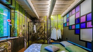A room with a bed, a window with a view of greenery, and a wall with a mosaic design. - Casalino Galassi 4 2 (Sarnano)
