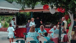 An outdoor dining area with tables and chairs, a grill, and a covered seating area. - MARİN HOTEL (Kemer)