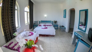 A hotel room with two beds, a desk, a mirror, and a TV. - MARİN HOTEL (Kemer)