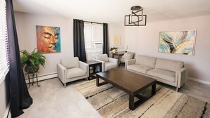 A living room with a sofa, two armchairs, a coffee table, a potted plant, and artwork on the walls. - The Overlook on Chocolate (Hershey)